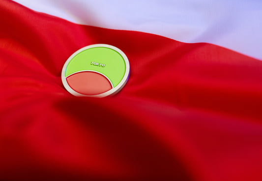 Abbott World Marathon Majors Tokyo collectible coin with bright green and coral colors displayed on red and white fabric.