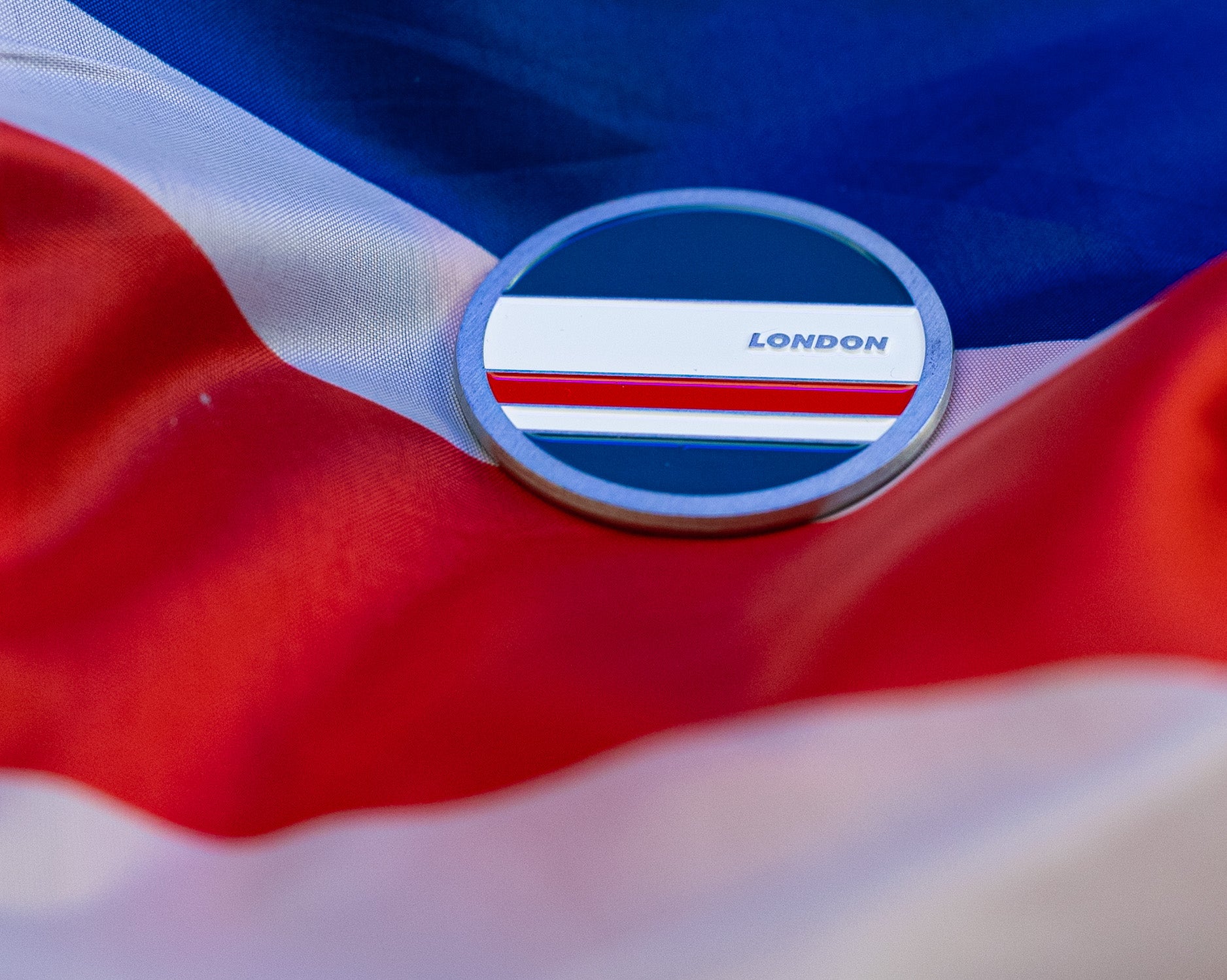 Abbott World Marathon Majors London collectible coin resting on a blue, white, and red fabric background.