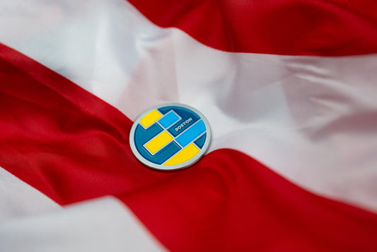 Abbott World Marathon Majors Boston collectible coin with blue and yellow geometric design on red and white fabric.