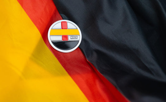 Abbott World Marathon Majors Berlin collectible coin with red, yellow, and black geometric design displayed on a German flag background.