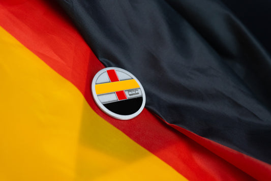 Abbott World Marathon Majors Berlin collectible coin with red, yellow, and black geometric design displayed on a German flag background.